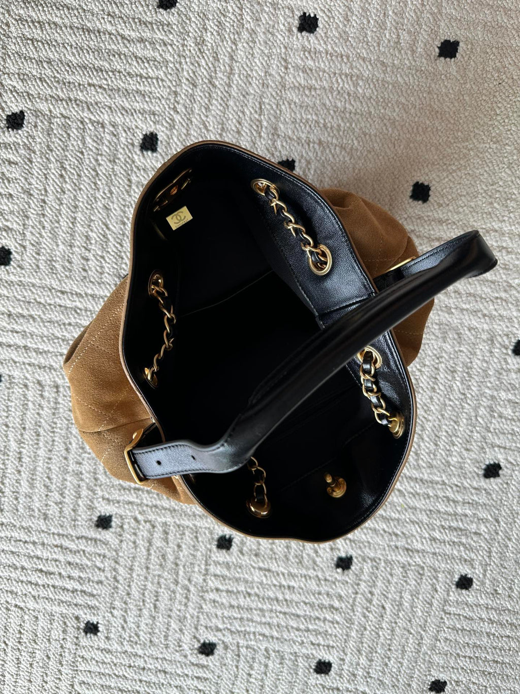 Two-tone handbag worn open view showing black interior lining and gold chain straps.