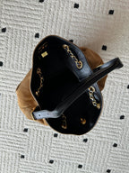Two-tone handbag worn open view showing black interior lining and gold chain straps.
