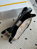 Chanel handbag open side view in taupe and black, chain strap, gold-tone hardware, CC charm.