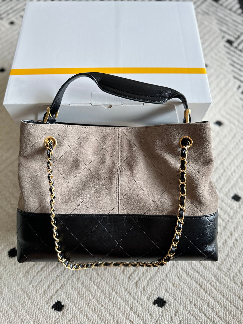 Chanel handbag in taupe and black with quilted center panel, long chain shoulder strap, CC logo.