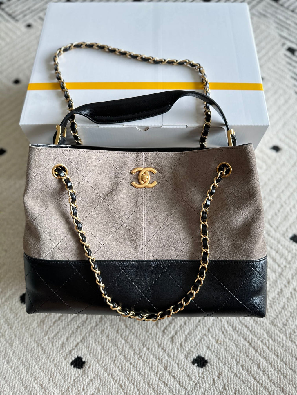 Chanel handbag in taupe and black with quilted panels, chain strap, top handle, CC logo.