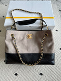 Chanel handbag in taupe and black with quilted panels, chain strap, top handle, CC logo.