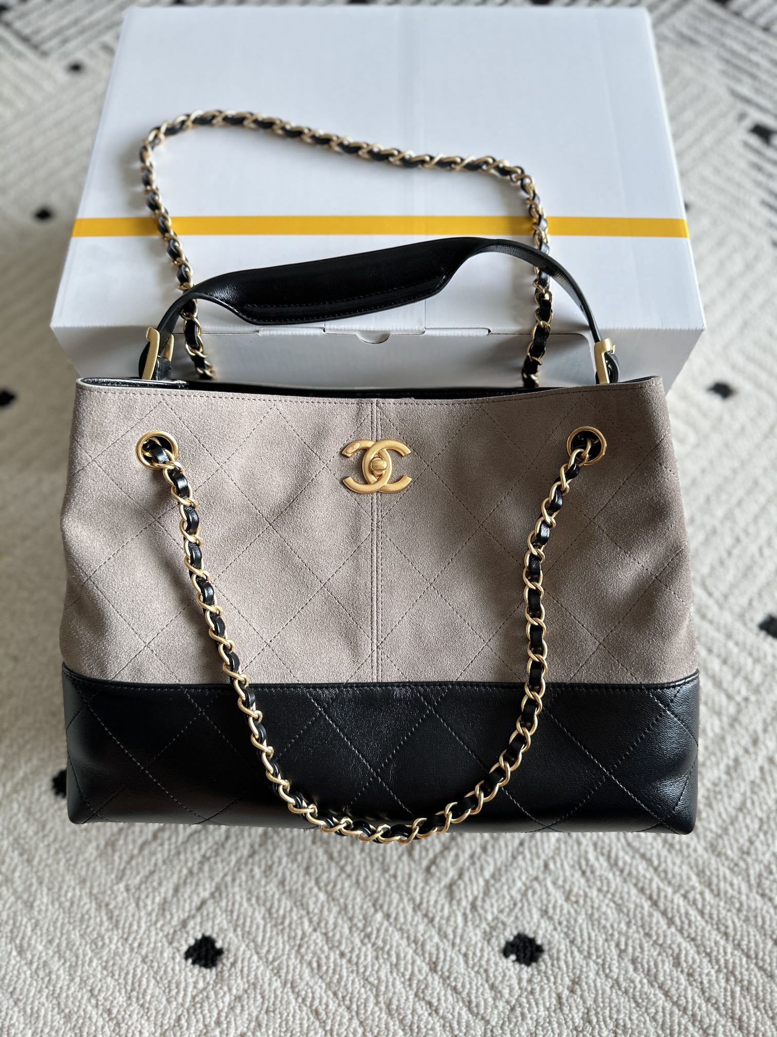 Chanel handbag in taupe and black with quilted panels, chain strap, top handle, CC logo.