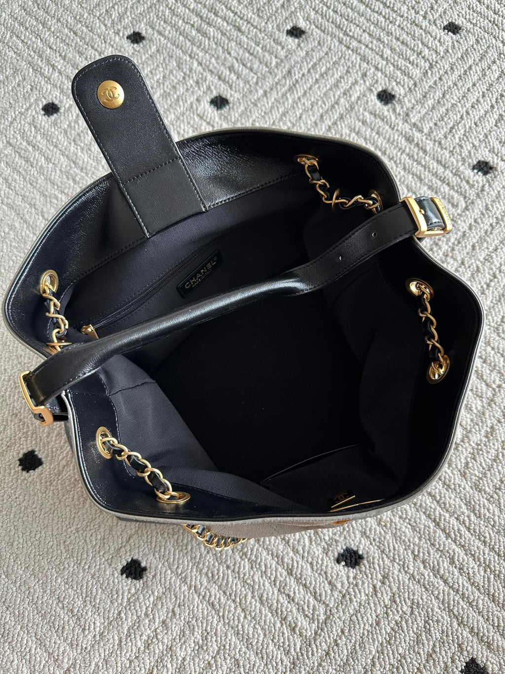 Chanel handbag open top with black interior, chain shoulder straps, gold-tone hardware, CC detail.