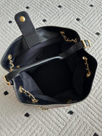 Chanel handbag open top with black interior, chain shoulder straps, gold-tone hardware, CC detail.
