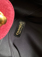 Black interior tag inside burgundy handbag with Chanel made in Italy text