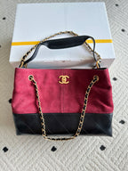 Two-tone handbag with chain strap, burgundy fabric and black front flap pocket
