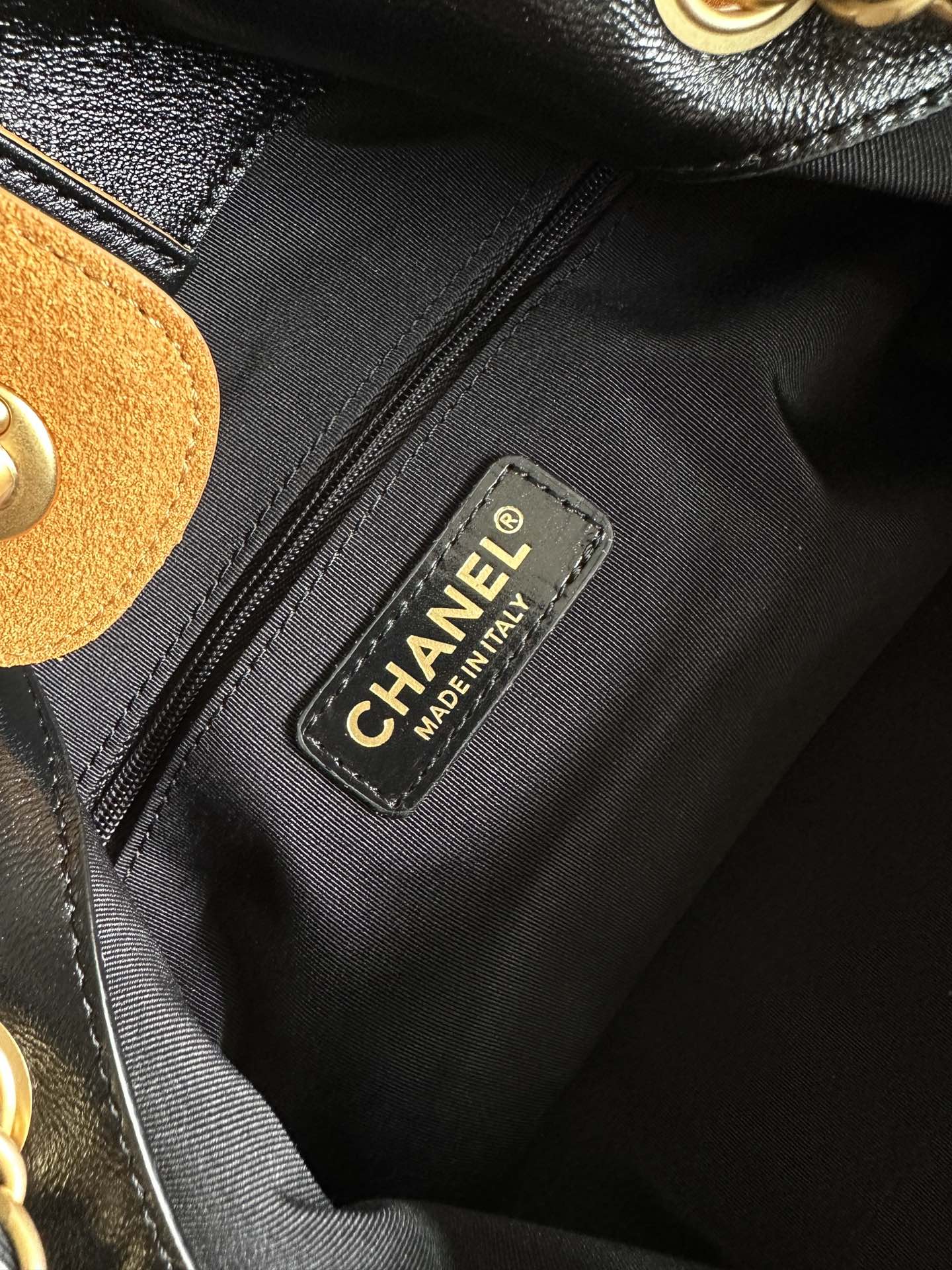 Black fabric interior label reading CHANEL and MADE IN ITALY on two-tone bag lining.