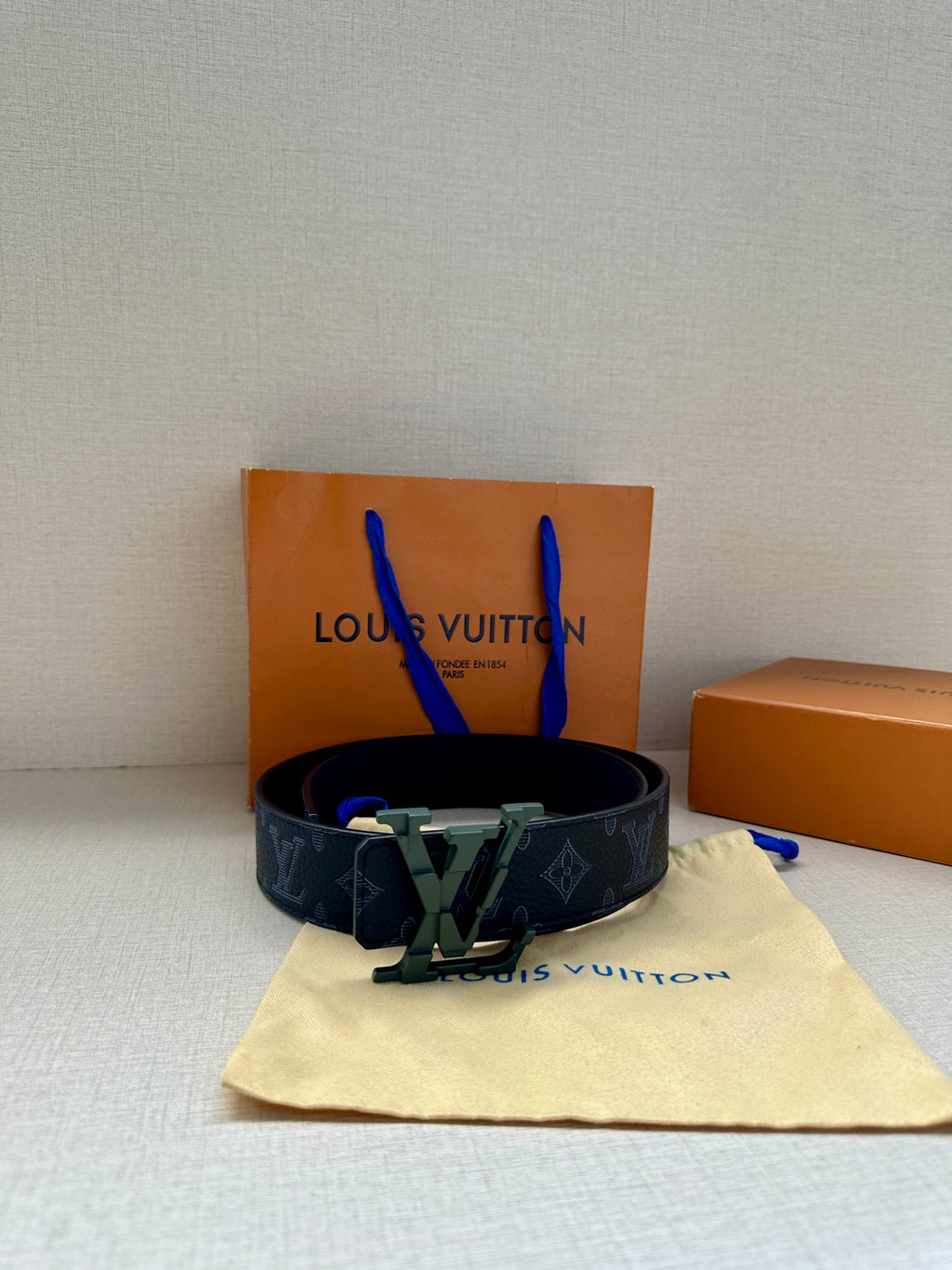 Monogram belt with dark blue strap and green LV-style buckle