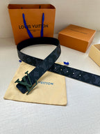 Monogram belt with dark blue strap and green buckle, extended strap end