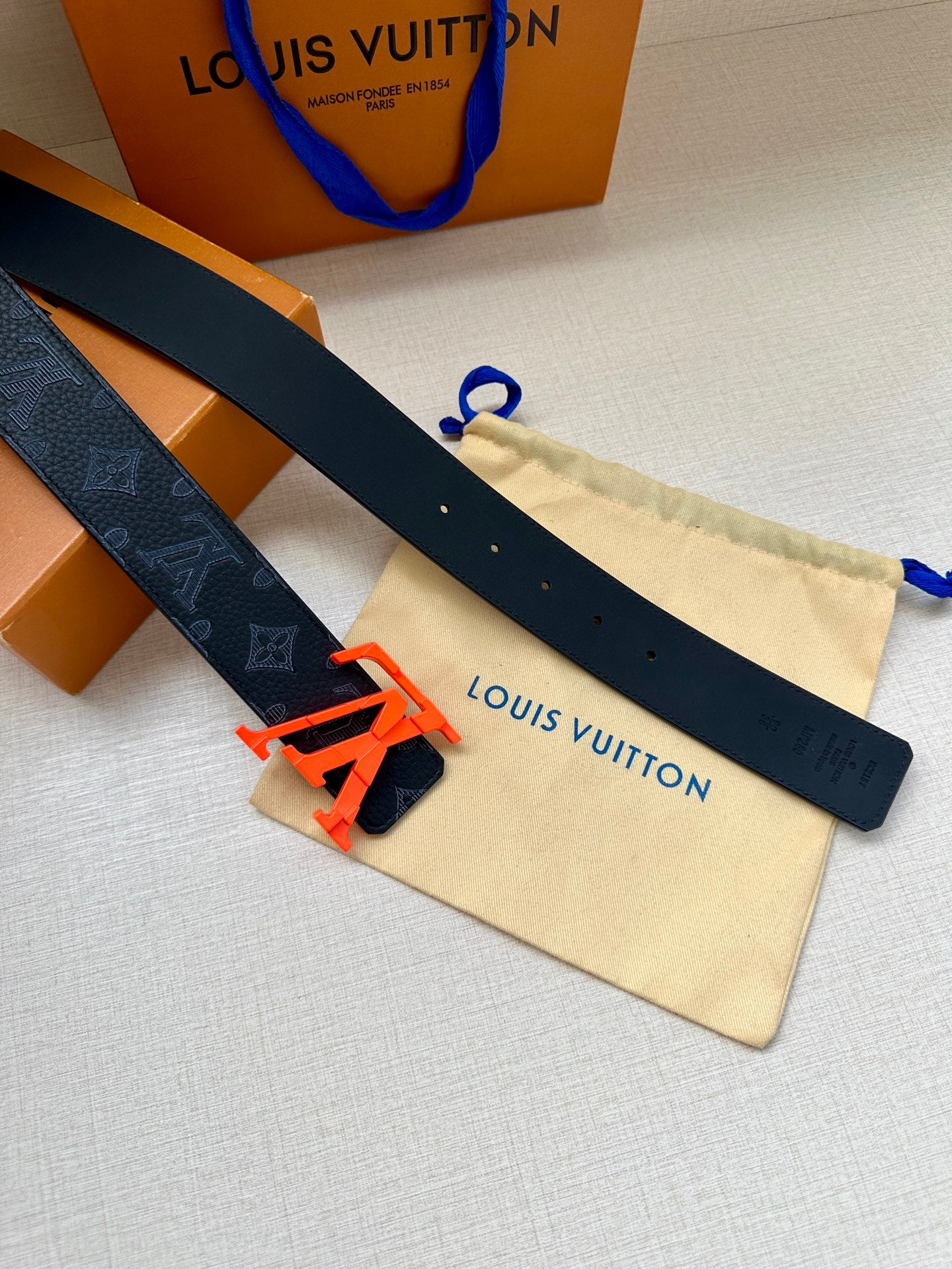 Louis Vuitton belt laid flat, dark monogram strap with LV buckle