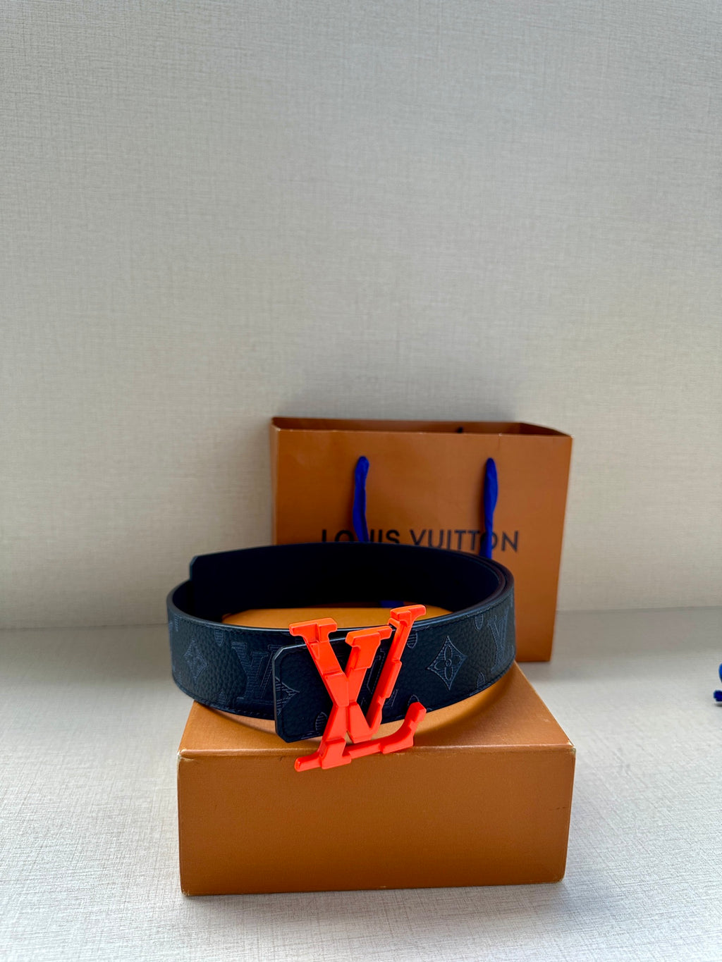 Louis Vuitton leather belt with dark monogram canvas strap and red LV buckle
