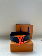 Louis Vuitton leather belt with dark monogram canvas strap and red LV buckle