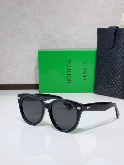 Black round sunglasses with dark lenses and small logo detail at the bridge