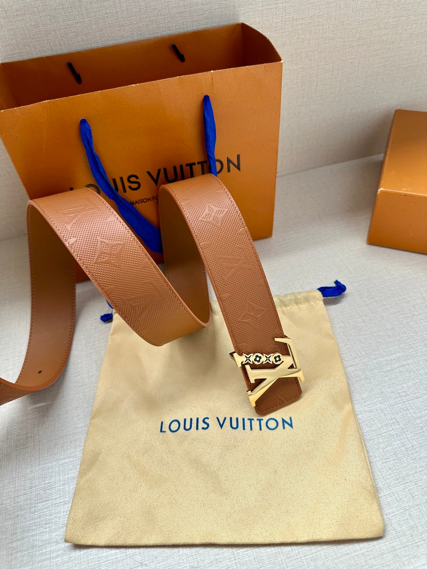 Louis Vuitton belt on fabric pouch, tan strap with gold LV buckle and embossed pattern