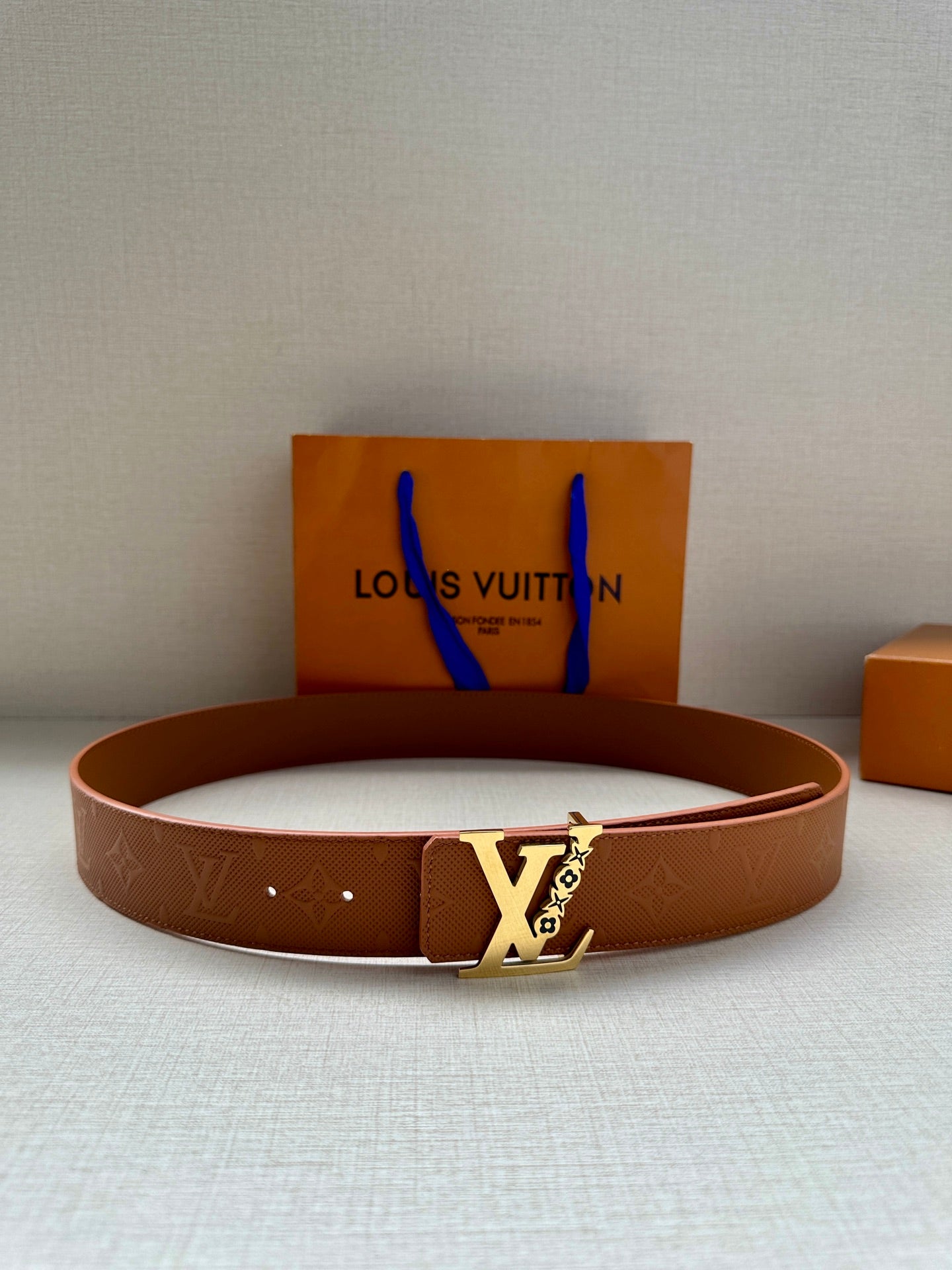 Louis Vuitton leather belt, tan/brown with embossed pattern and gold-tone LV buckle