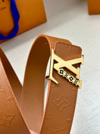 Louis Vuitton belt with tan leather strap and gold buckle with LV logo, side view