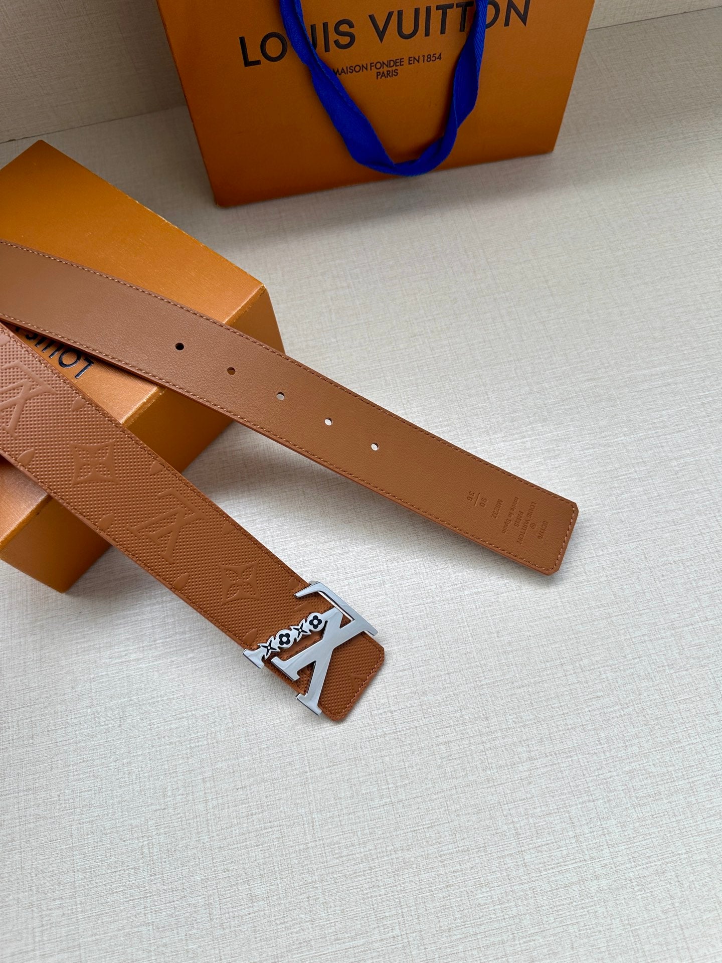 Louis Vuitton belt with tan leather strap, gold square LV buckle and adjustment holes