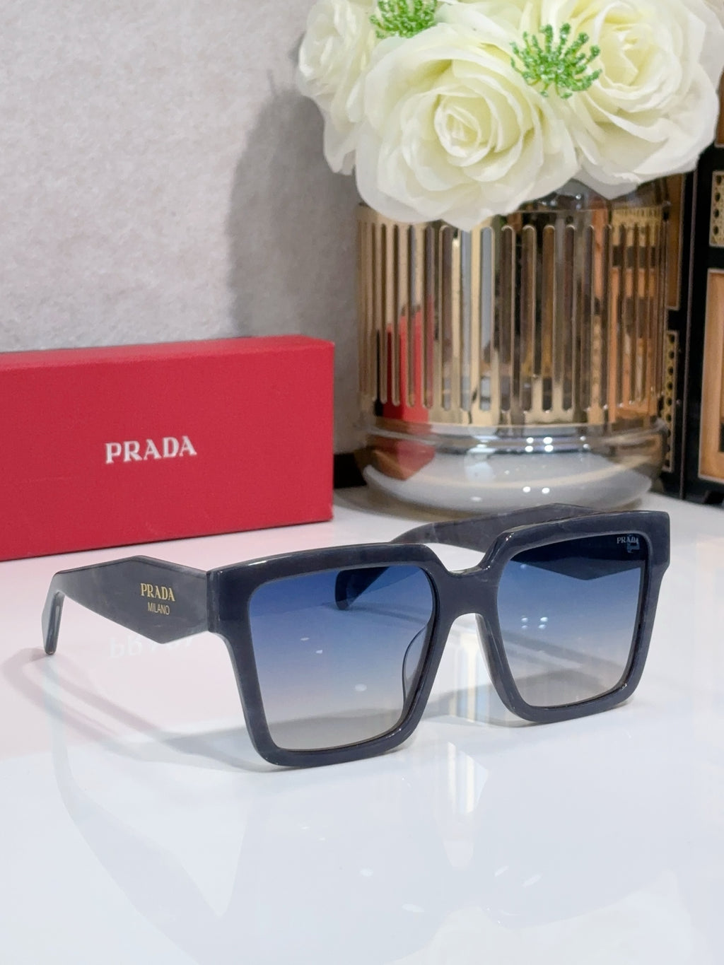 Prada dark blue square sunglasses with thick frames and tinted lenses