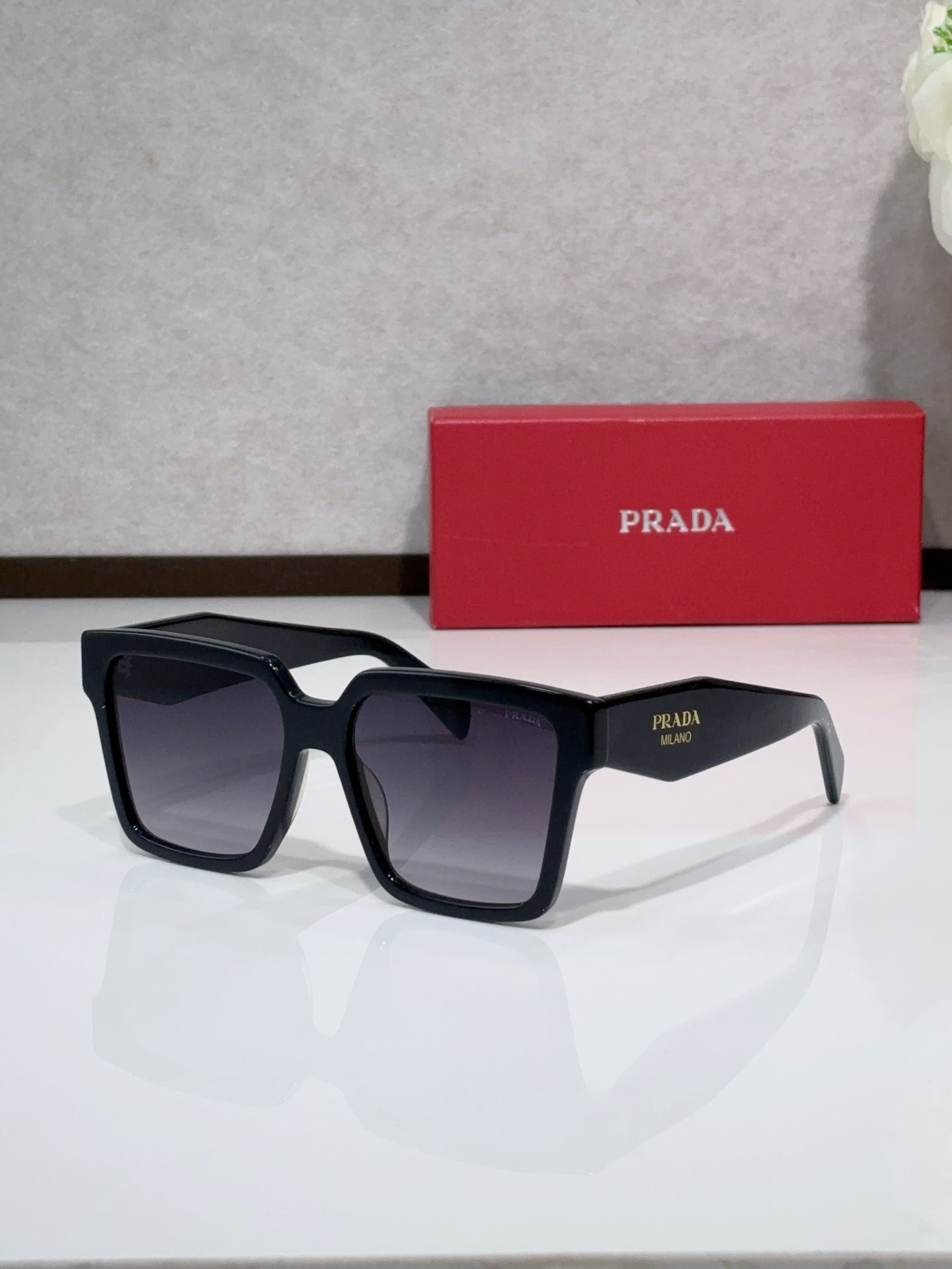 Prada black square sunglasses with thick acetate frames and dark gradient lenses