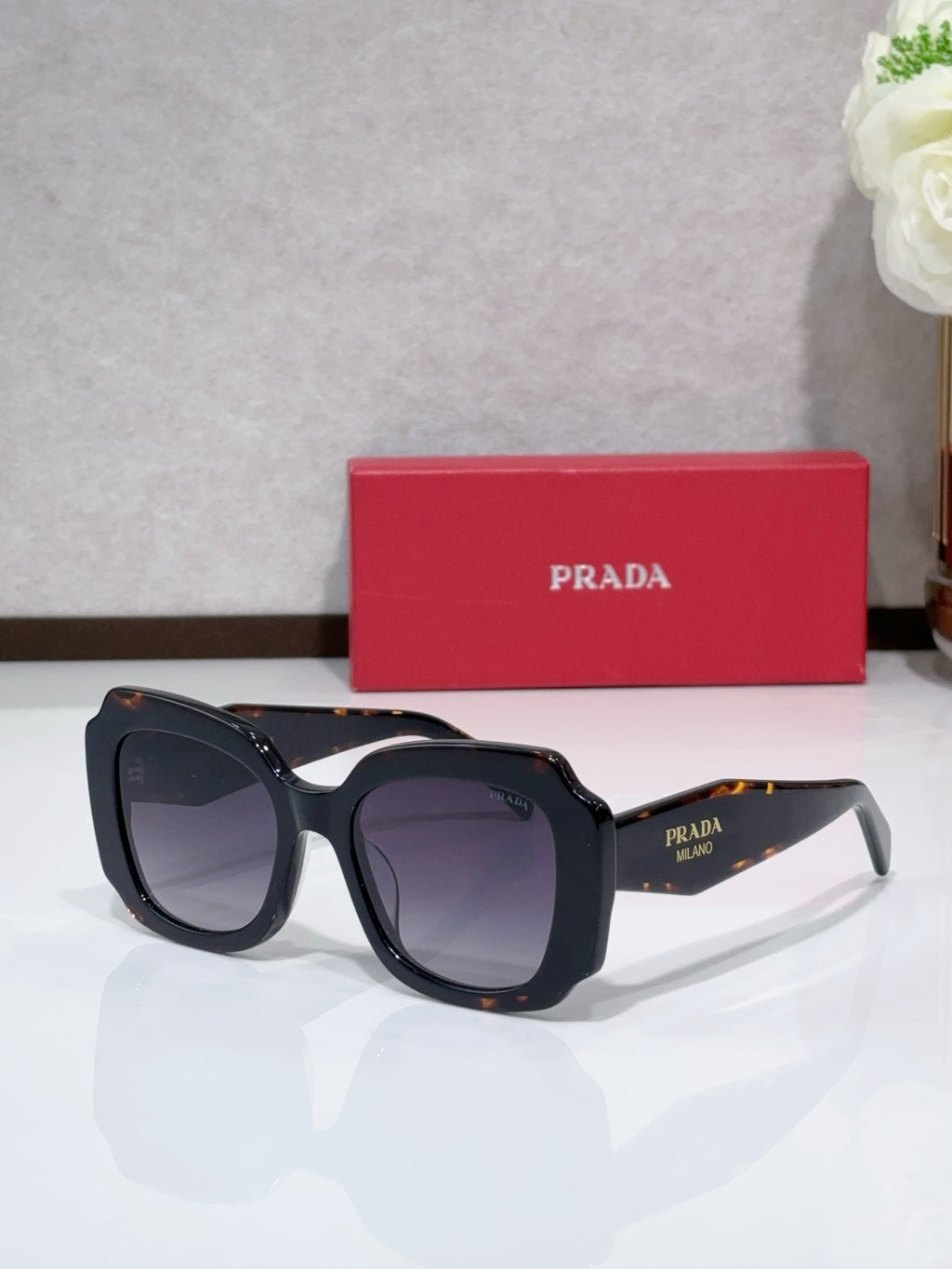 Prada sunglasses, black frame with dark tinted lenses and angled arms