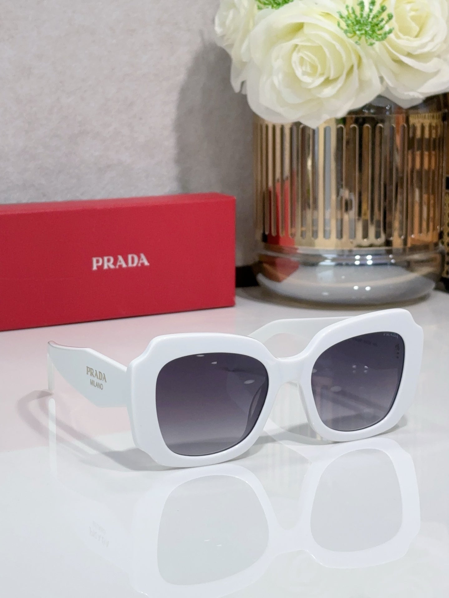 Prada sunglasses, white frame with dark lenses and Prada detail on temple