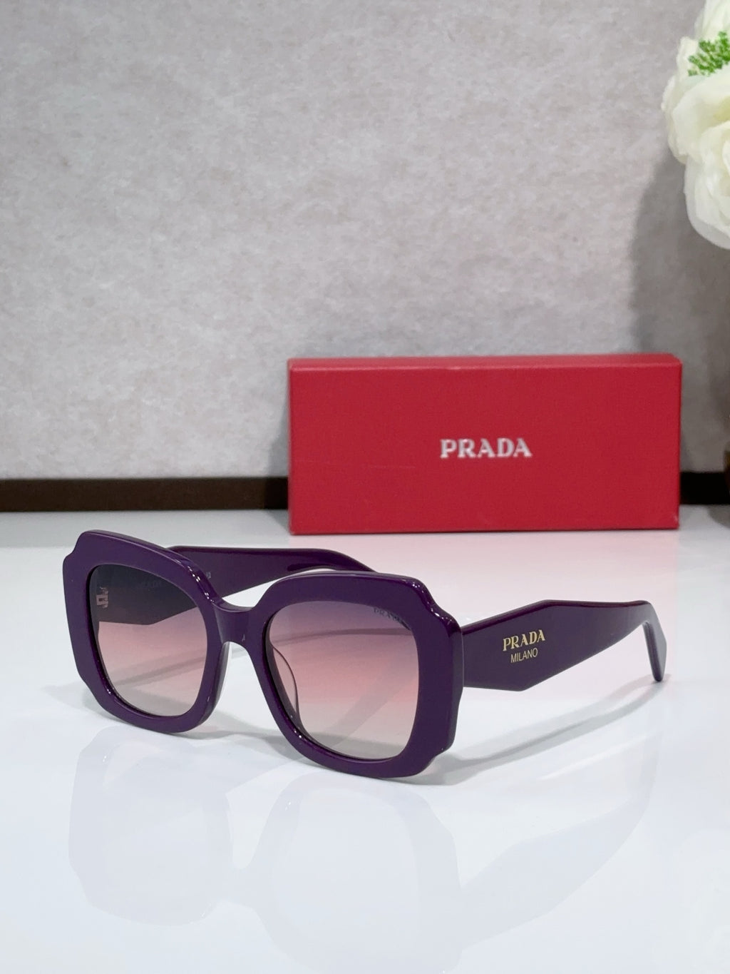 Prada sunglasses, purple frame with tinted lenses and dark temple text