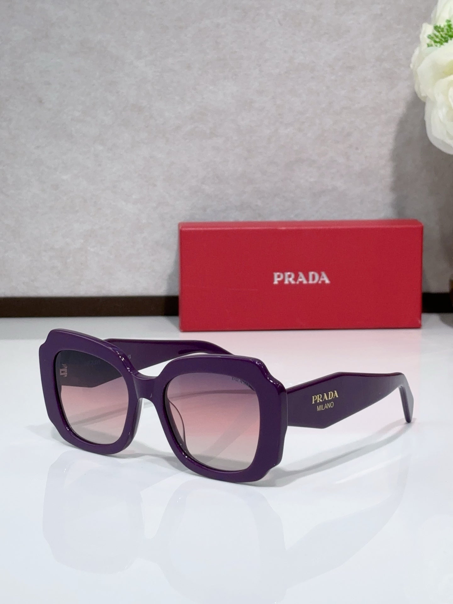 Prada sunglasses, purple frame with tinted lenses and dark temple text