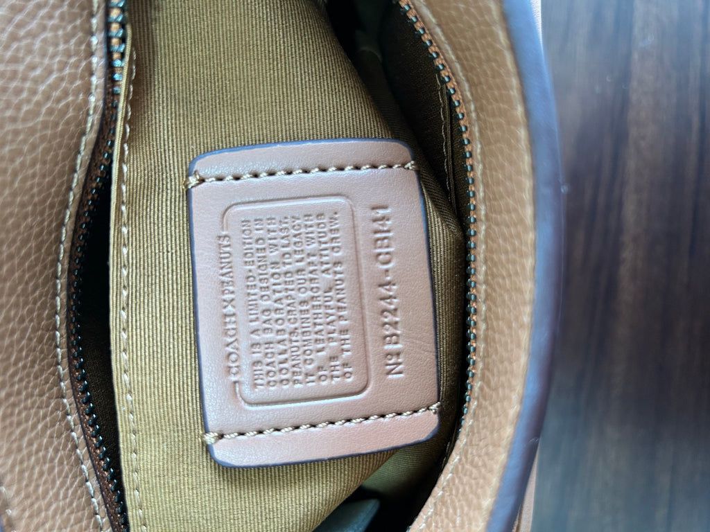 Coah bag interior label on beige patch with embossed text