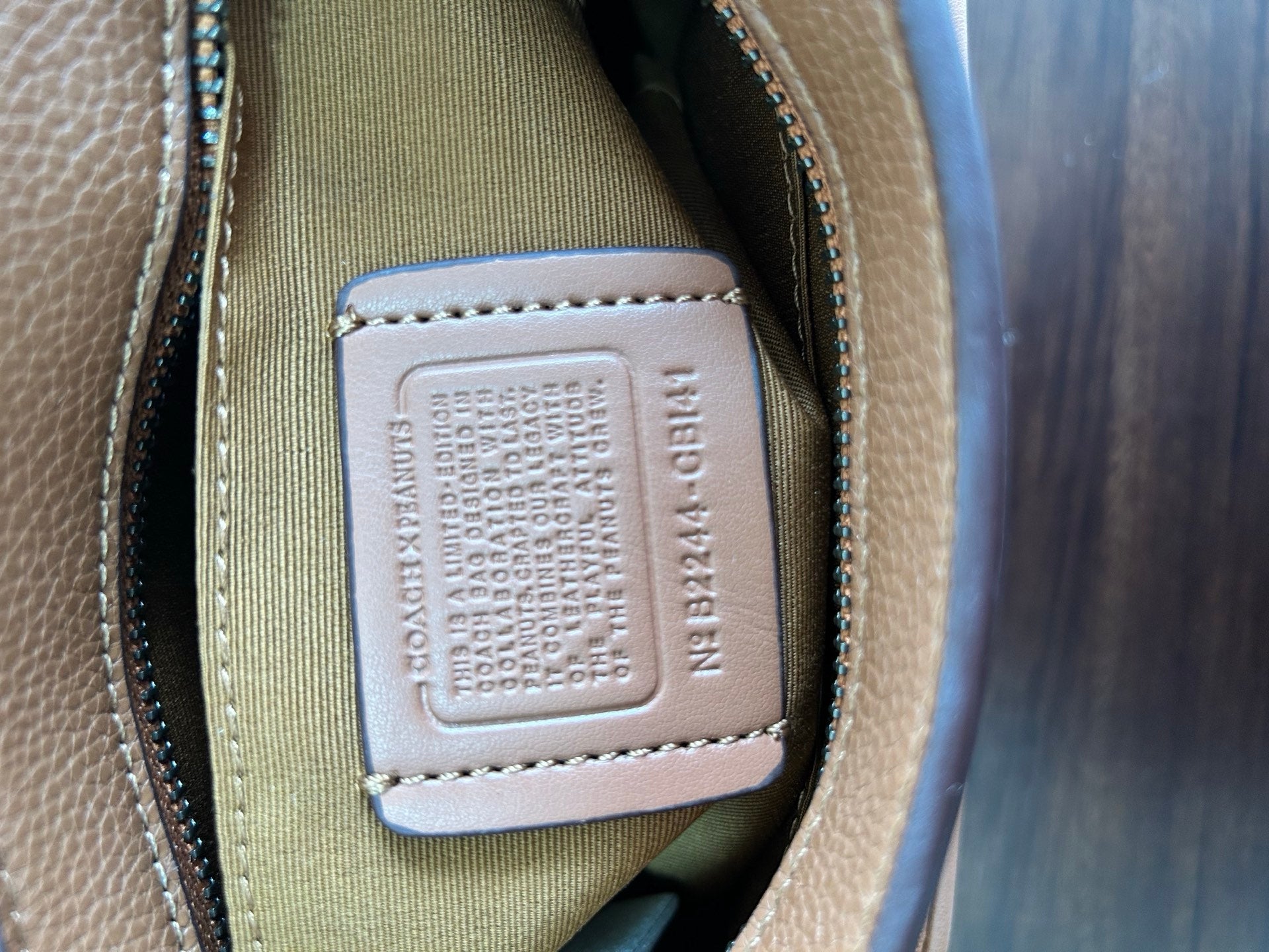 Coah bag interior label on beige patch with embossed text