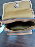 Coah bag open top with green fabric lining and zippered opening