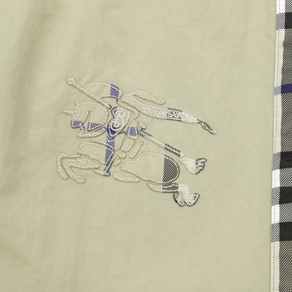 Beige pants with embroidered animal-style graphic on the front panel