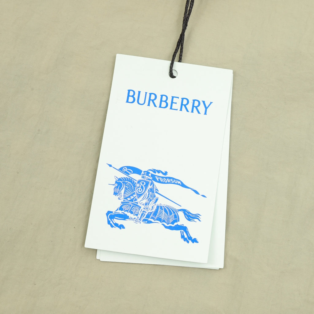 Burberry hang tag attached to beige pants with embroidered detail