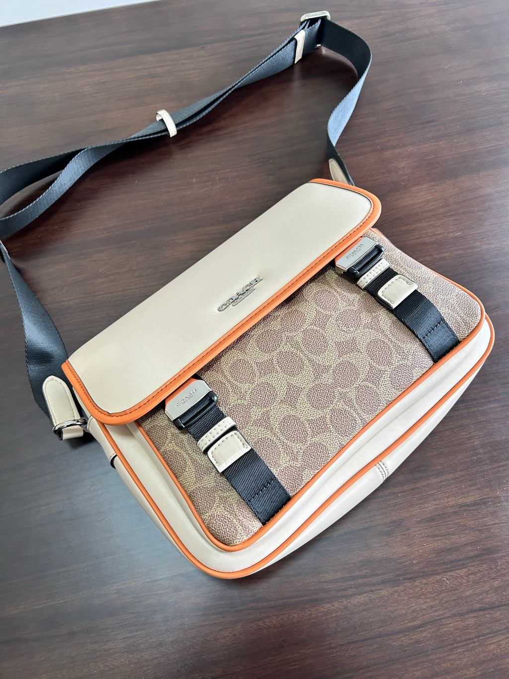 Beige crossbody bag open top showing patterned interior and adjustable strap