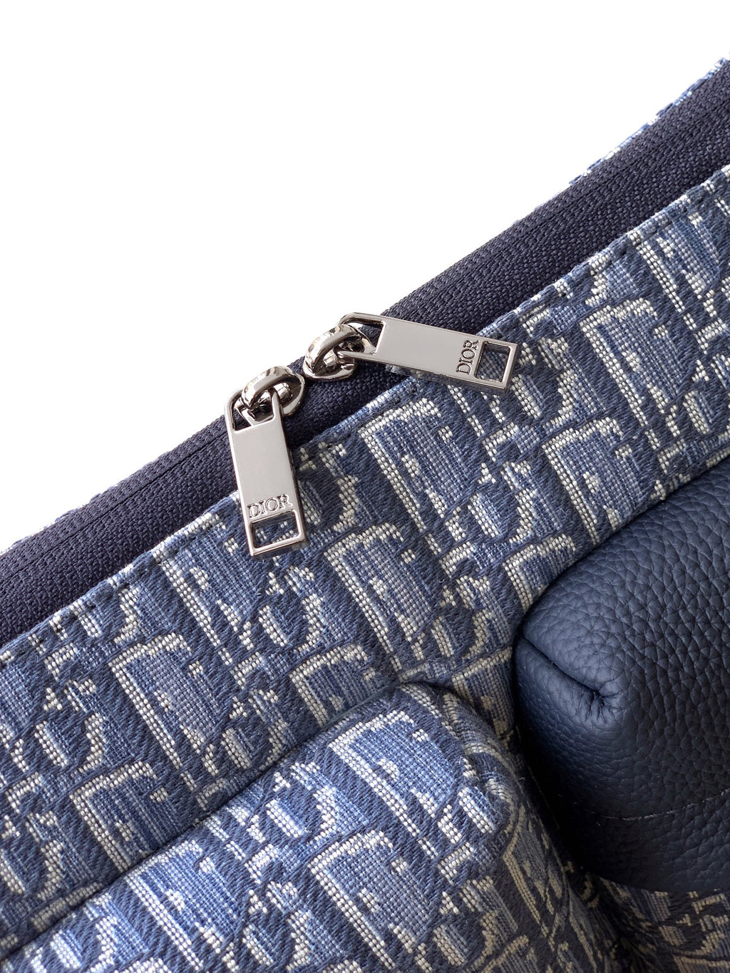 Dior men’s bag strap detail with metal clasp and light blue monogram fabric