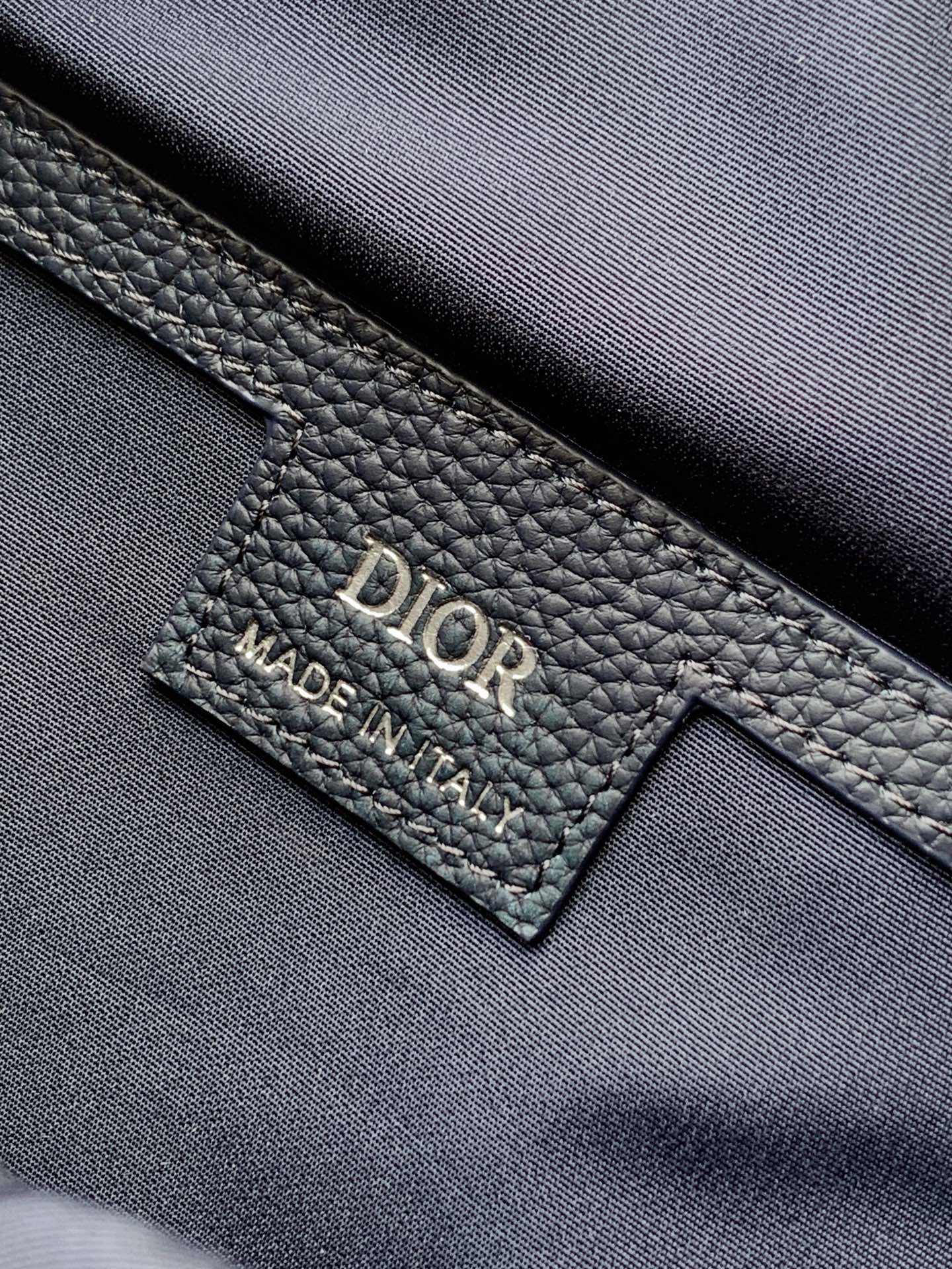 Dior bag leather label showing 'DIOR' and 'MADE IN ITALY'