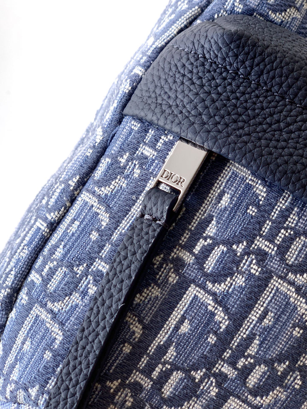 Blue Dior monogram fabric with black textured trim and metal clasp detail.