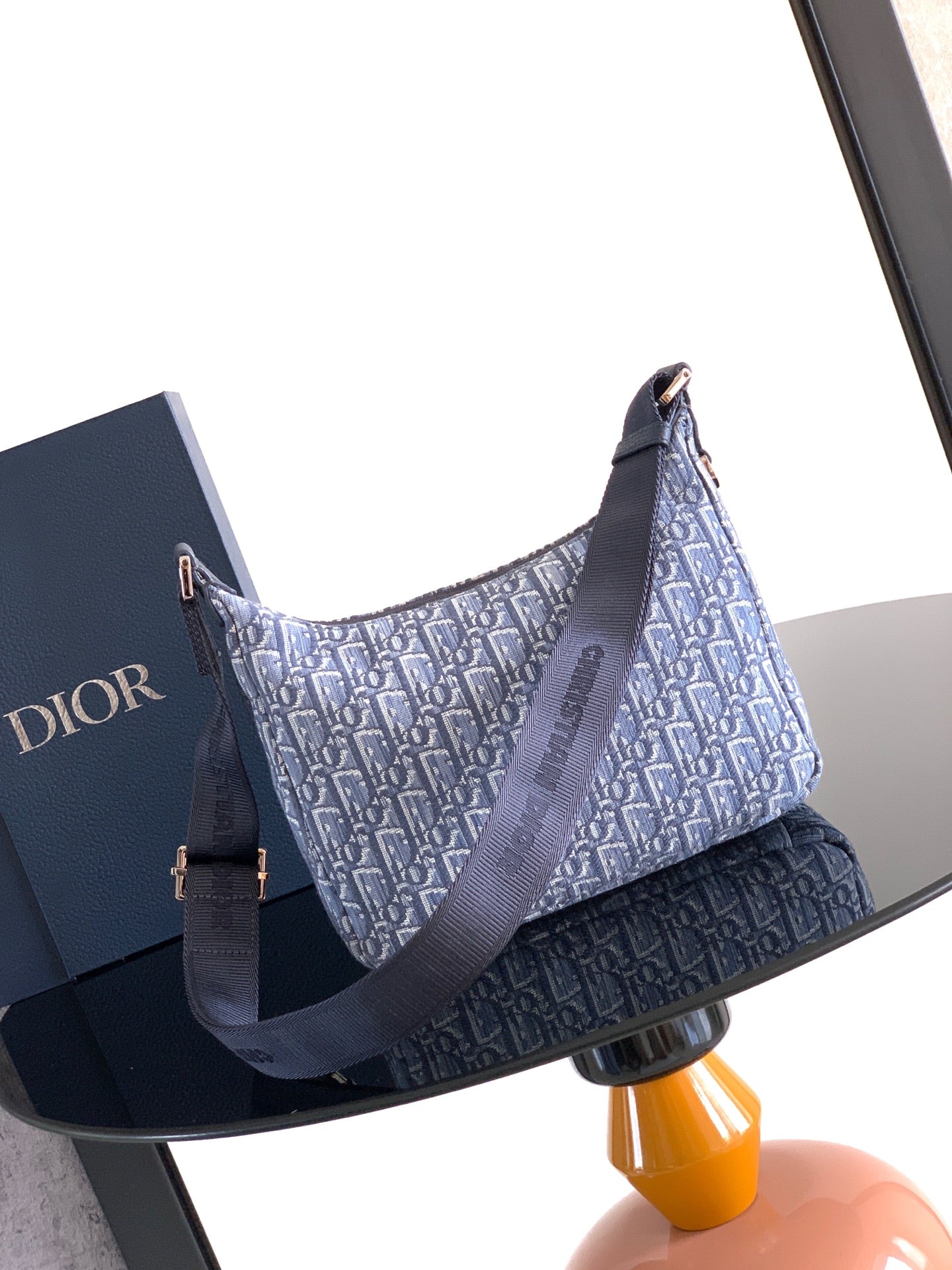 Blue Dior monogram shoulder bag with long adjustable strap and side handle.