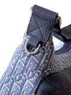 Blue Dior monogram bag with gold-toned buckle and textured leather corner trim.