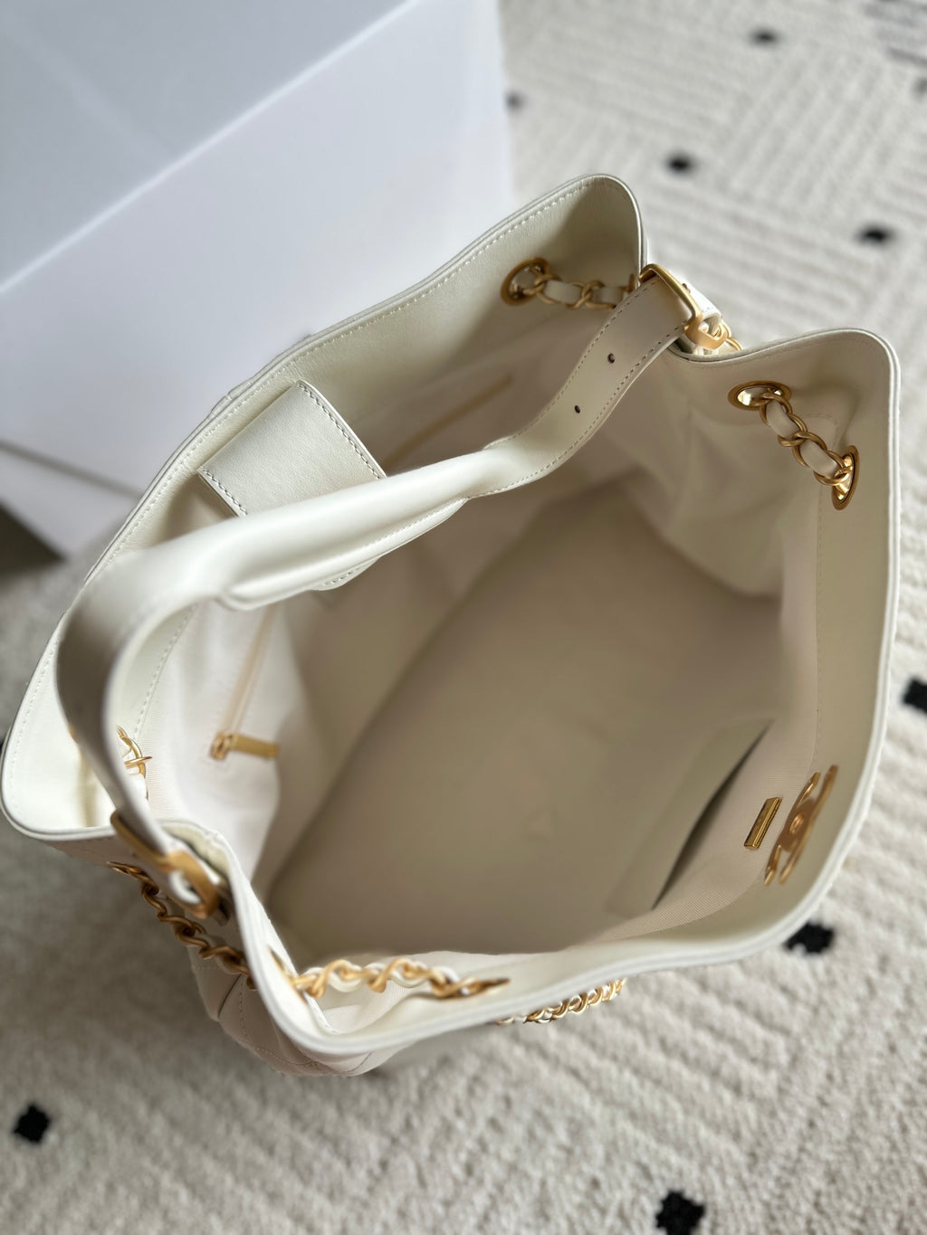 Open white Chanel quilted bag interior with gold chain detail