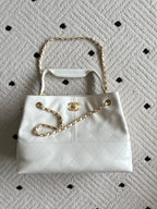 White quilted Chanel mini bag with gold chain shoulder straps and CC logo