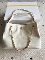 White quilted Chanel mini bag with gold chain handle and CC logo front