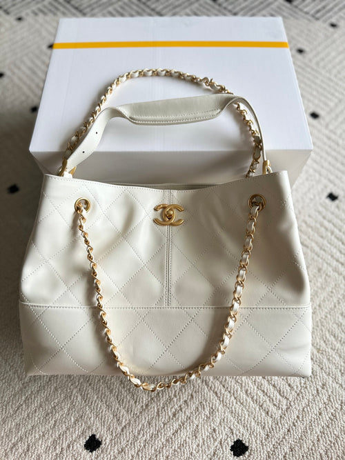 White quilted Chanel mini bag with gold chain handle and CC logo front