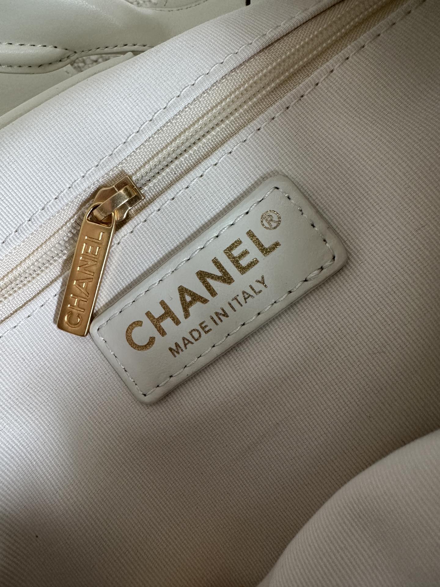 White Chanel bag interior patch with gold buckle and CHANEL Made in Italy