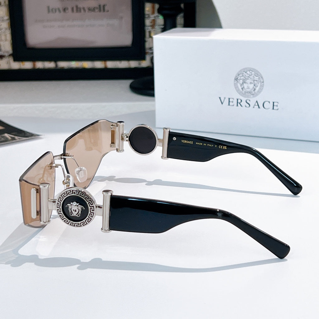 Versace sunglasses with black lenses, gold hinges, and Medusa emblem on wide temple plates
