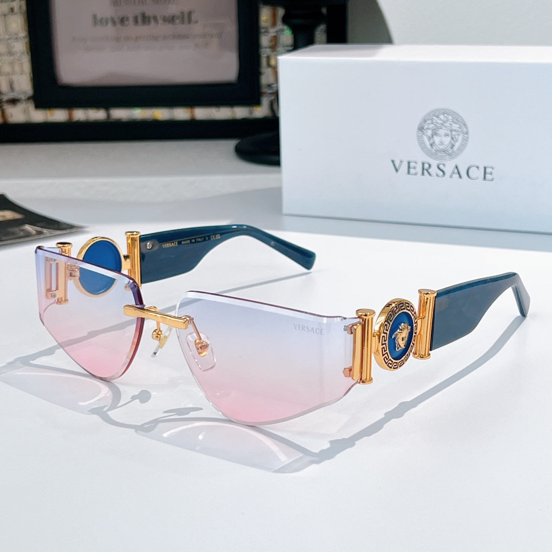 Versace sunglasses with gold frame, pink-to-clear lenses, and blue emblem accents on temples