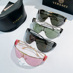 Stack of shield sunglasses with green, dark gray, and pink mirrored lenses on gold frames.