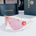 Sunglasses with gold-tone frame and pink lenses, round red logo medallion on temple.
