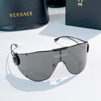 Shield sunglasses with dark gray lenses and slim black temples, round logo on side.