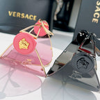 Pink shield sunglasses with gold-tone frame, round pink logo medallion on temple.